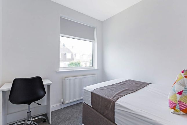 A Bright And Tidy Single Bedroom Featuring A Comfo...