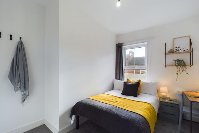 A Bright And Welcoming Bedroom Featuring A Comfort...