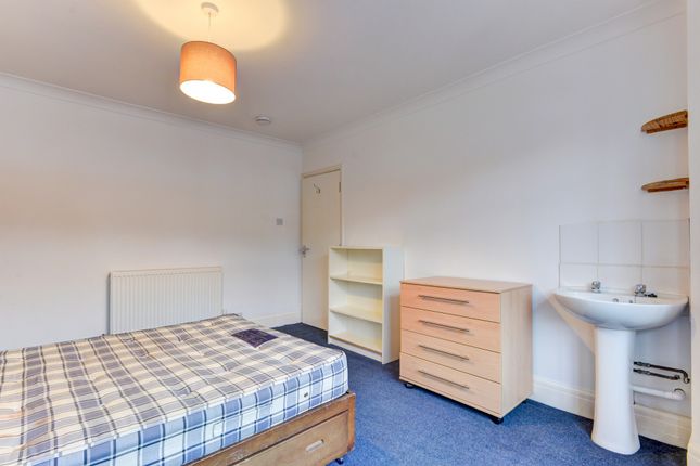 A Well-Maintained Bedroom Featuring A Double Bed, ...