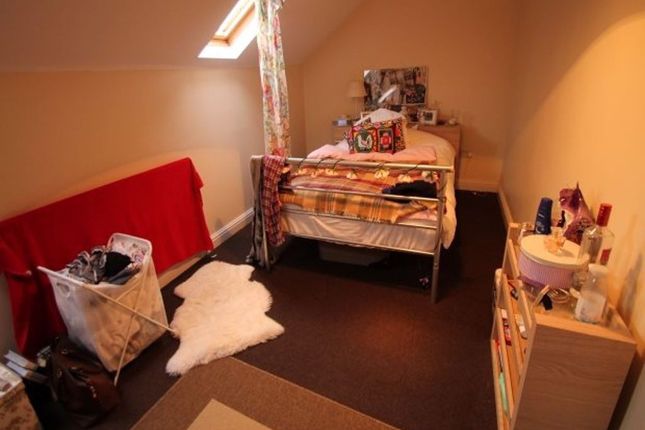 A Cozy Bedroom Featuring A Single Bed With Colorfu...