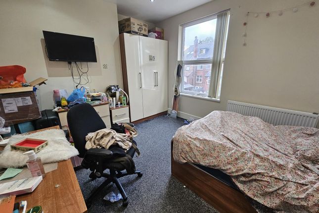 A Cozy Bedroom Featuring A Bed Covered With A Patt...