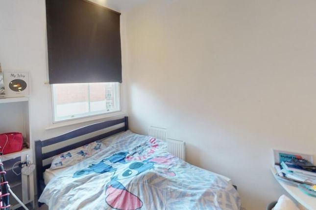 A Cozy Single Bedroom Featuring A Neatly Made Bed,...