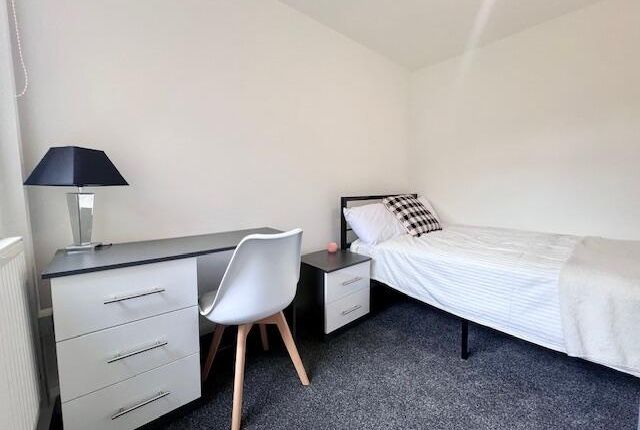 A Neat And Bright Single Bedroom Featuring A Comfo...