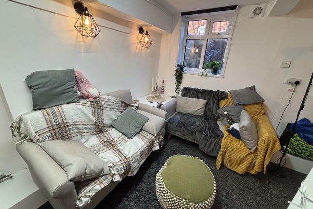 A Cozy And Well-Lit Living Room Featuring Comforta...