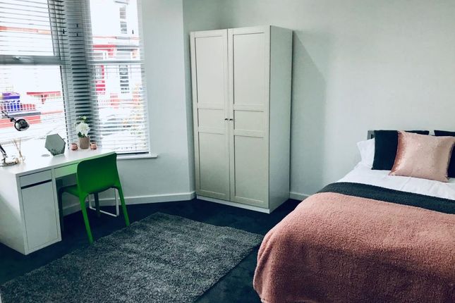 A Bright And Tidy Bedroom Featuring A Bed With Coo...