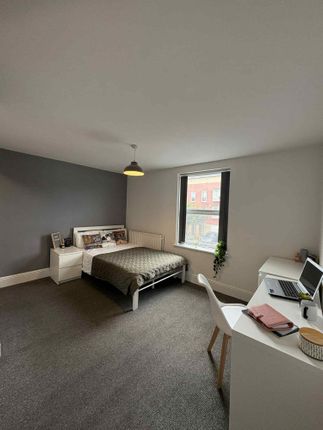 A Spacious And Bright Bedroom Featuring A Comforta...