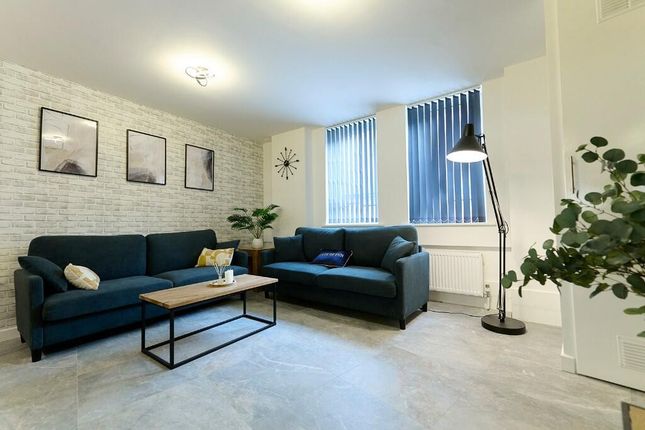 A Bright And Stylish Living Room Featuring Two Com...