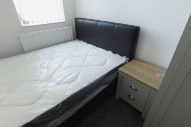 A Tidy Bedroom Featuring A Double Bed, A Small Bed...