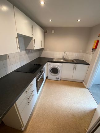 Modern And Tidy Kitchen Featuring Sleek Black Coun...