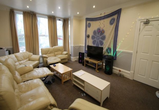 A Spacious And Well-Lit Living Room Featuring Comf...