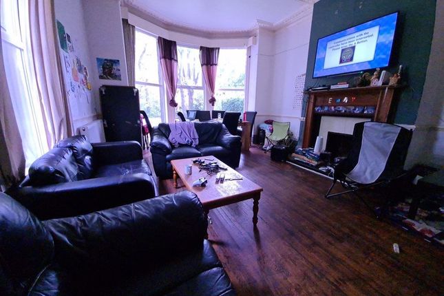 A Charming Living Room Featuring A Bay Window With...