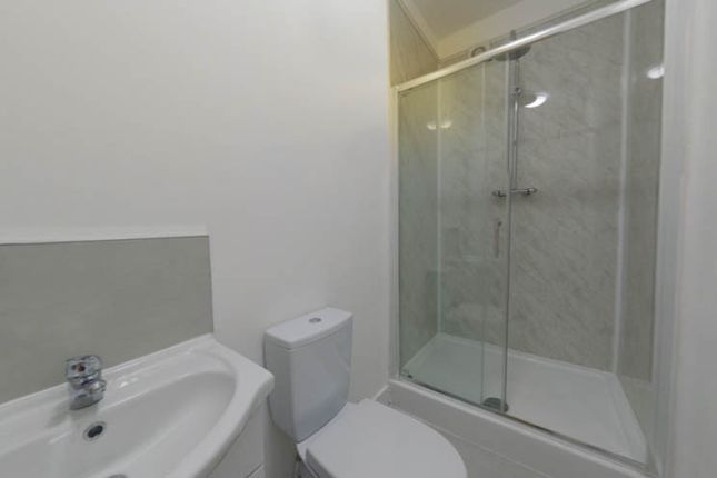 A Clean And Functional Bathroom With A Shower Encl...