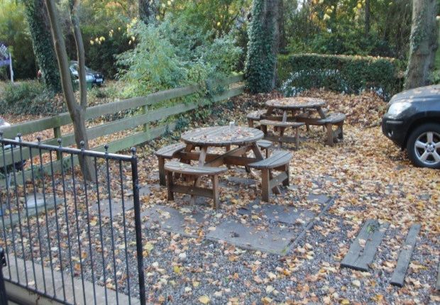 An Outdoor Garden Area With Several Picnic Tables ...