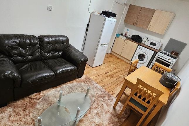 A Cozy Living Area Featuring A Black Leather Sofa,...