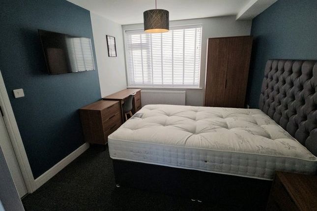 A Stylish Master Bedroom Featuring A Comfortable d...