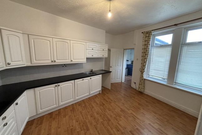 A Spacious, Well-Lit Kitchen With Ample White Cabi...