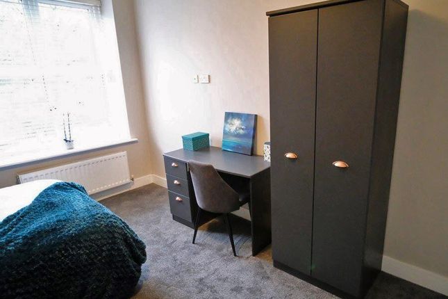 A Bright And Tidy Single Bedroom Featuring A Comfo...