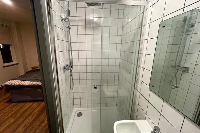 A Modern Ensuite Bathroom Featuring White Tiled Wa...