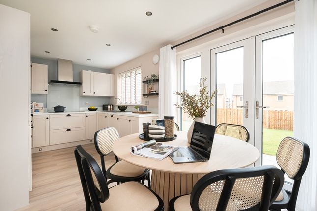 A Modern Kitchen And Dining Area With French Doors To The Rear Garden