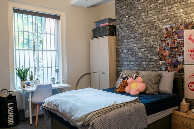 A Cozy Single Bedroom With A Neatly Made Bed, Soft...