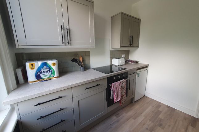 A Modern Kitchen Featuring Sleek Grey Cabinetry An...