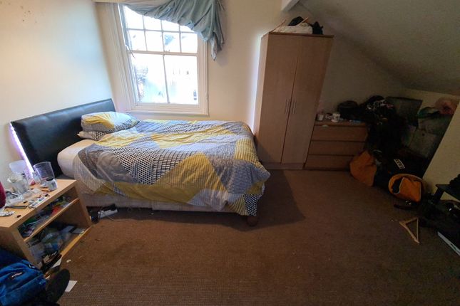 A Cozy Attic Bedroom With A Single Bed Positioned ...