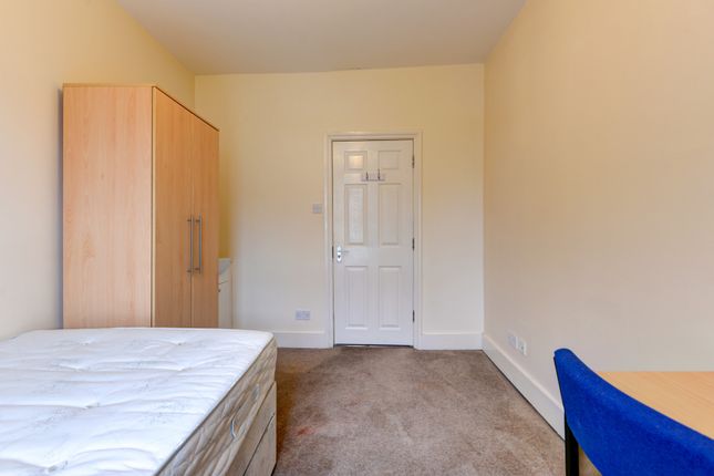 A Simple, Clean Bedroom Featuring A Bed And A Ward...