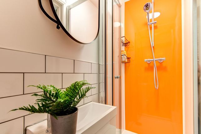 This Modern Bathroom Features A Bright Orange Acce...