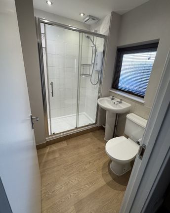A Clean, Modern Bathroom Featuring A Shower With G...