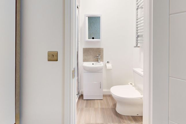 A Modern, Tidy Bathroom Featuring A White Toilet, ...