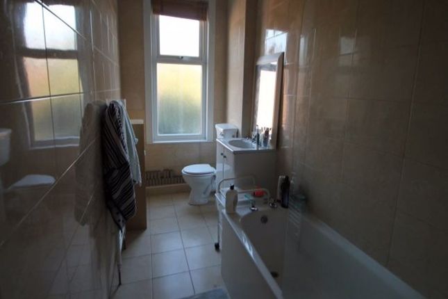 A Clean And Well-Lit Bathroom Featuring A Bathtub,...