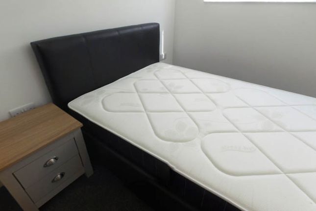 A Tidy Bedroom With A Comfortable Bed, A Nightstan...