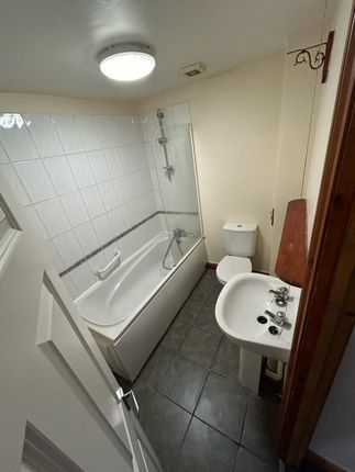 A Functional Bathroom Featuring A Bathtub With A S...