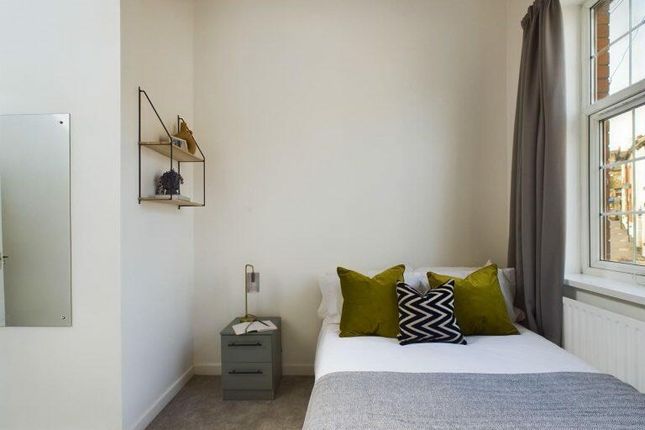 A Cozy Single Bedroom Featuring A Neatly Made Bed ...