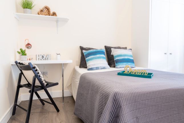 This Inviting Double Bedroom Features A Comfortabl...