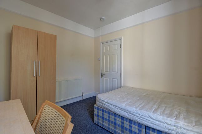A Simple And Tidy Single Bedroom Featuring A Woode...