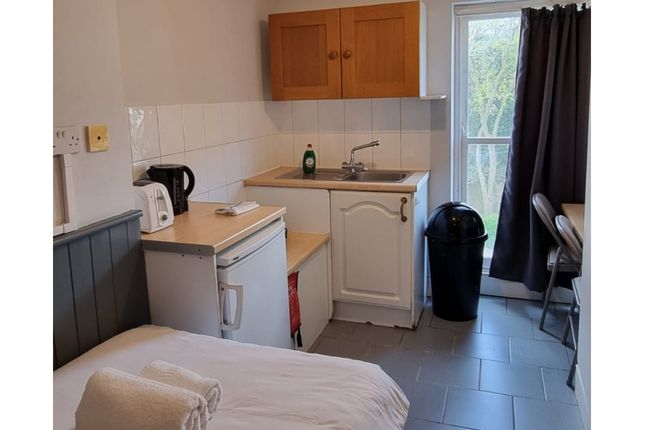 A Tidy Kitchenette With Essential Appliances And A...