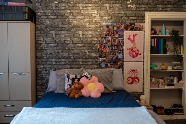 A Cozy Bedroom Featuring A Bed With Plush Toys, A ...