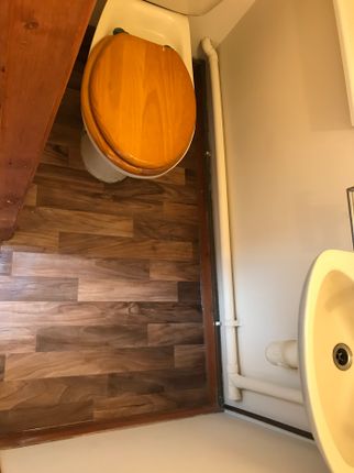 A Tidy And Functional Single Toilet Area Featuring...