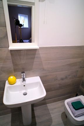 A Modern And Clean Bathroom Featuring A White Pede...