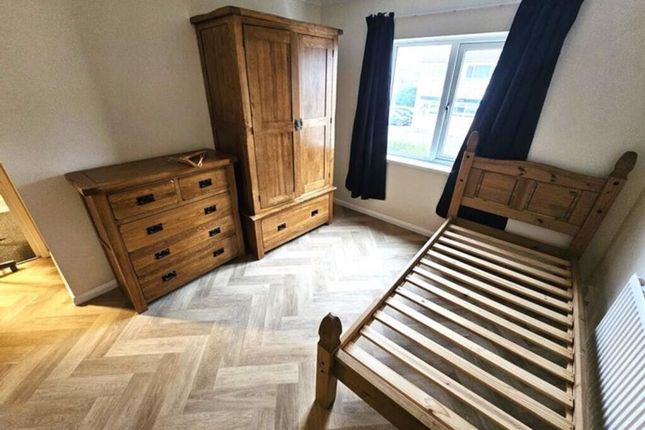 A Tidy, Well-Lit Bedroom Featuring Wooden Furnitur...