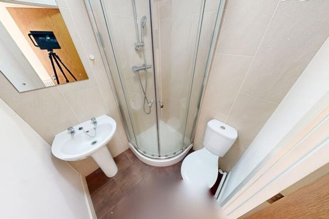 A Compact And Tidy Bathroom Featuring A Curved Gla...