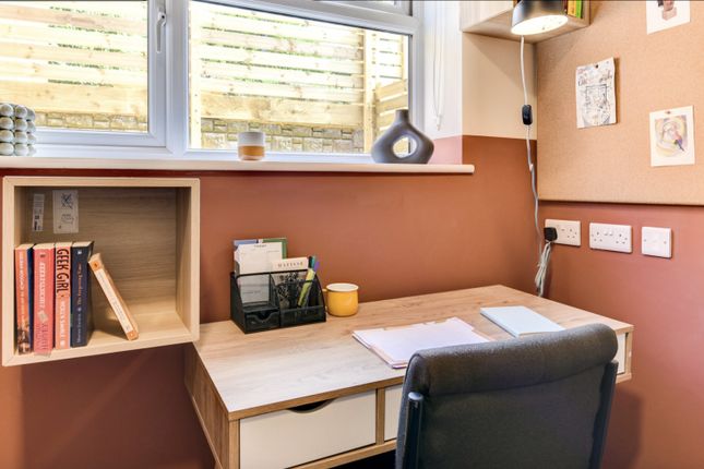 A Cozy And Well-Lit Communal Workspace Featuring A...