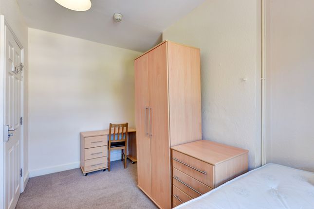 A Neat And Orderly Bedroom Featuring A Single Bed,...