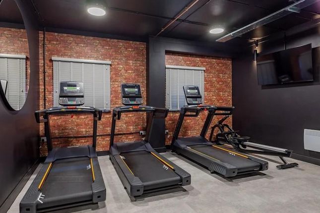 A Well-Maintained Gym Area Equipped With Treadmill...