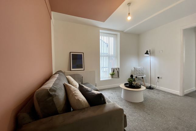 A Bright And Inviting Living Room With A Cozy Sofa...