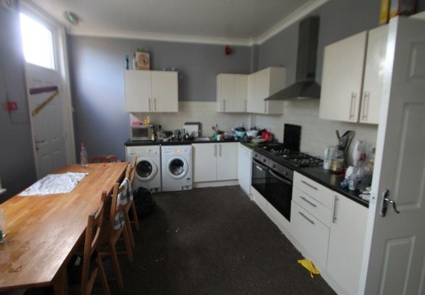 A Modern Kitchen With White Cabinetry And Applianc...