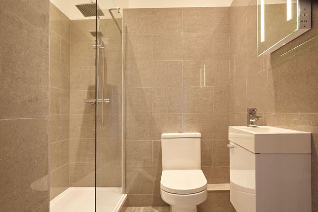 A Modern And Clean Bathroom Featuring A Shower And...