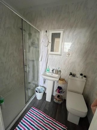 Bright And Clean Bathroom Featuring A Shower Enclo...