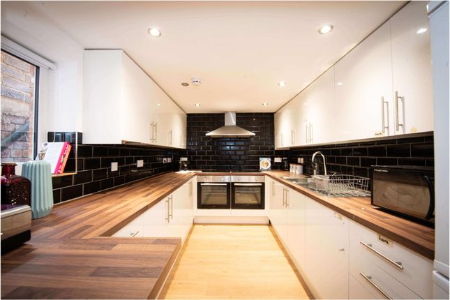 A Modern Kitchen With Sleek Black And White Cabine...